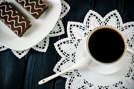 Table setting with cookies with chocolate and coffee drink. Coffee and cakes in chocolate sauce on a wooden black table.の写真素材