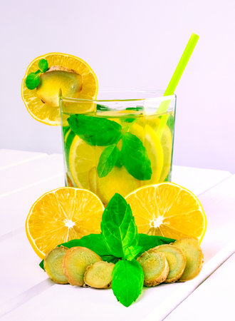 Drink in a glass on a white wooden table. Drink with lemon, ginger and mint.の写真素材