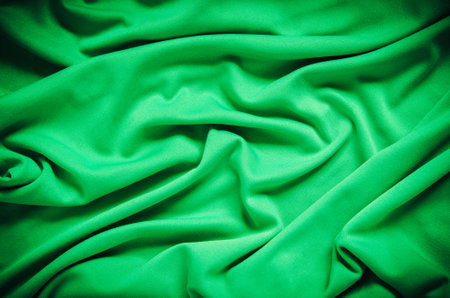 Green wrinkled fabric texture. Close-up of soft cotton cloth, may be used as background.の写真素材