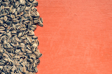 Sunflower seeds on a pile. Healthy food on a wooden table, may be used as background.の写真素材