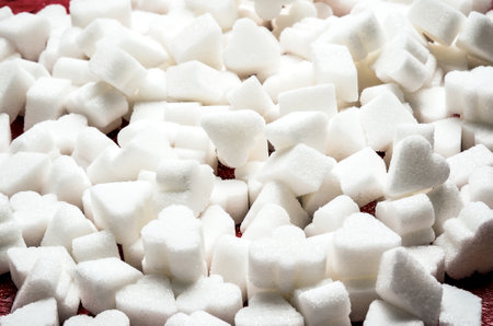 Concept with white unhealthy sugar. Sugar cube on a brown wooden table.の写真素材