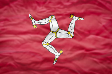 Isle of Man flag on a wavy background. Wavy flag of Isle of Man fills the frame.の写真素材