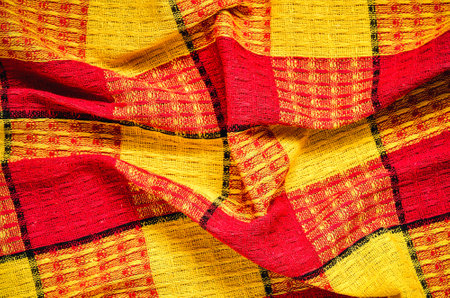 Wrinkled texture material rag. Red and yellow fabric background checkered.の写真素材