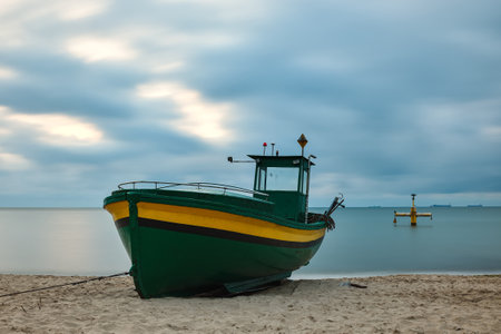 Morning landscape over the Polish Baltic Sea. Fishing boat on the beach in Gdynia Orlowo, Poland. Photo with long exposure effect.の写真素材