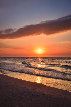 Beautiful colorful sunset over the sea. Sandy beach in the evening on the Polish Baltic Sea.の写真素材