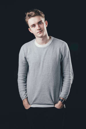 Man posing for the camera on dark background.