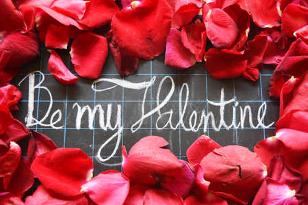 Happy Valentines day! text on blackboard on background of rose petalsの写真素材