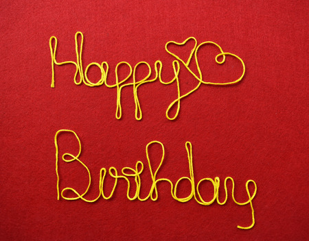 birthday ribbon greeting and hearts on red backgroundの写真素材