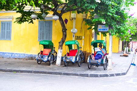 An unidentified rider passing an ancient cyclo service house