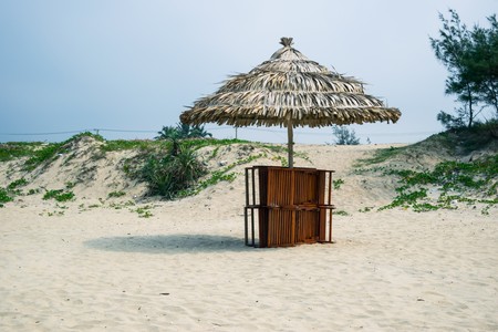 Beach chairs on the white sand beach with cloudy blue sky and sunの写真素材