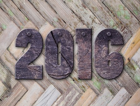 The word "2016" written in rusty metal letterpress type sitting on a wooden ledge background.の写真素材
