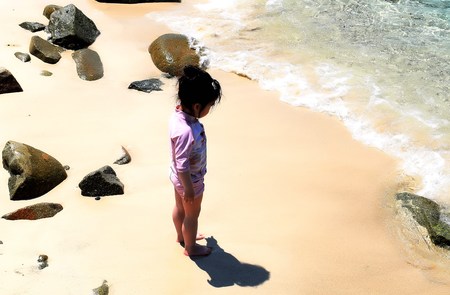 Girl standing at the beach. Shadow of her body over the sandのeditorial素材