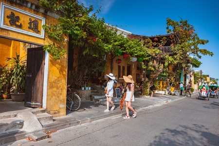 HOI AN, VIETNAM - MARCH 15, 2017: Group of people travel Hoian old town, ancient house, country heritage, city friendly with environment, walk, bicycle or pedicab on street, traveller visit at Vietnamのeditorial素材
