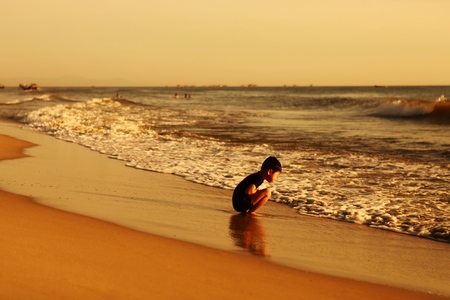 QUANG BINH, VIETNAM - AUGUST 11, 2017: Kid sunbathing on the beach at sunrise time.のeditorial素材