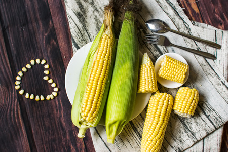 Fresh corn on cobs on wooden table, closeup, top viewの写真素材