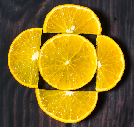 Slices of orange on wood background. top view