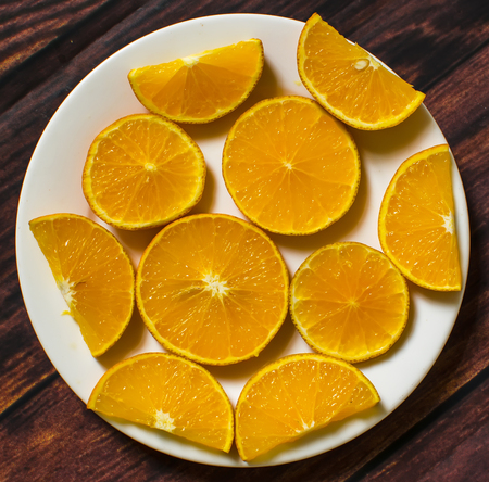 Slices of orange on wood background. top viewの写真素材