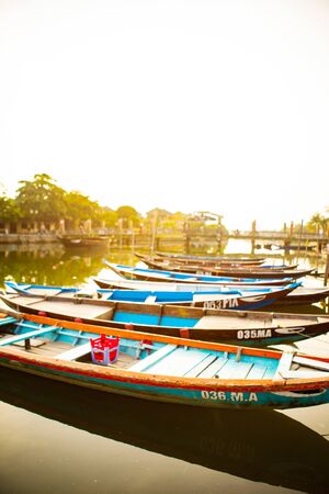 HOI AN, QUANG NAM, VIETNAM, April 26th, 2018: Boats by the river in ancient town Hoi An with view of typical yellow housesのeditorial素材