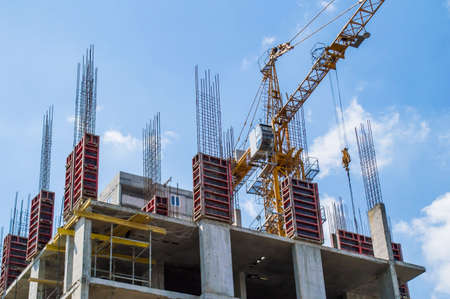 House construction, crane against the spring sky