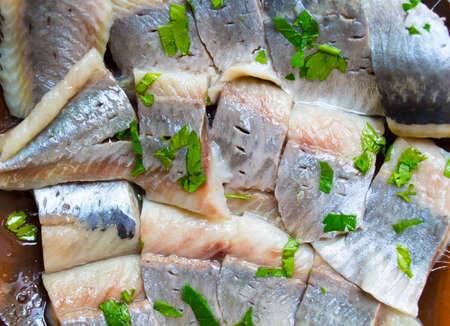 Fillet of a marinated light-salted herring with greens