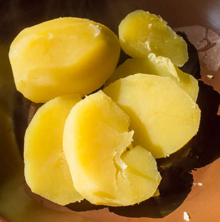 Boiled potatoes without peel on a brown dishの写真素材