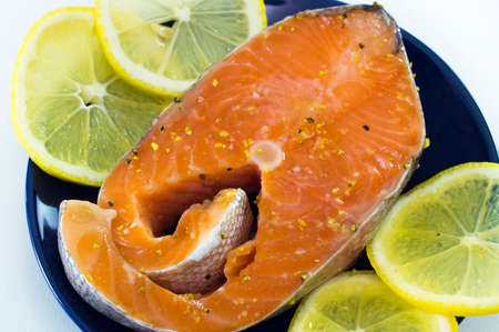 The Norwegian trout with lemons on a blue dishの写真素材