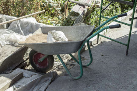 Construction tools and materials: wheelbarrow, cement and sandの写真素材