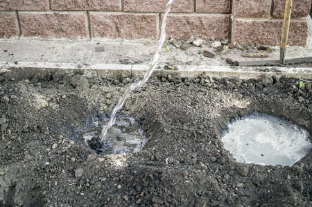 Watering of the dug-up earth a water stream