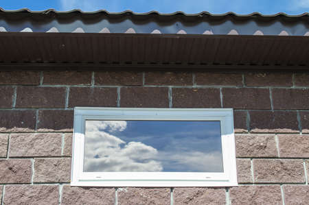 The polymeric window in the house with brick walls