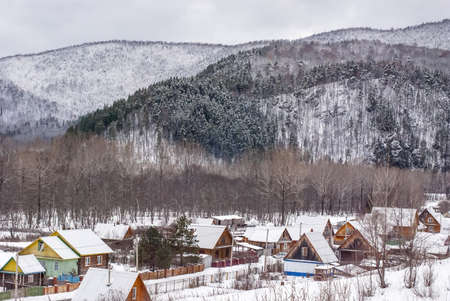 The settlement in the woody mountains brought by snowの写真素材