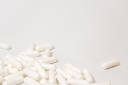 Medicine and Supplement Capsules Scattered on White Background
