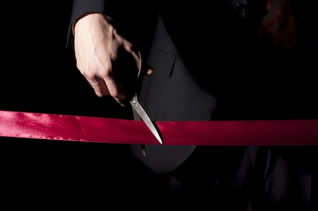 man in a suit, cuts a red tape, opening of event
