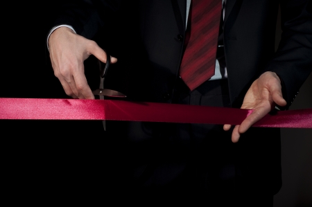man in a suit cut red tapeの写真素材