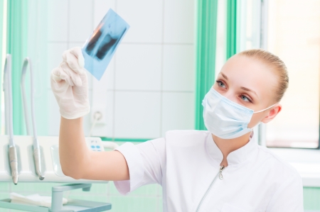 woman doctor in protective mask looking at x-rayの写真素材