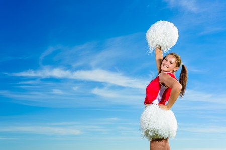 Young cheerleader in red costume with pamponの写真素材