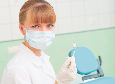 female dentists in protective mask holds a dental tool, doctors at workの写真素材