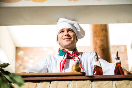 portrait of a cook, behind a stone table and looks aheadの写真素材