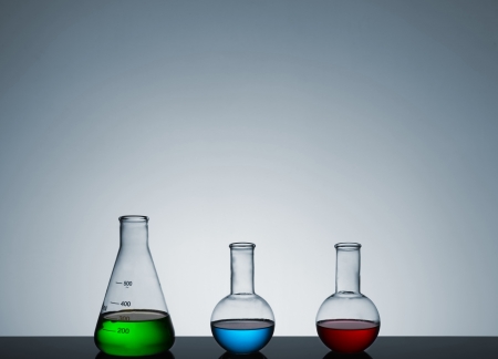 test tubes with colored liquid on a gray background, a still life, a place for textの写真素材