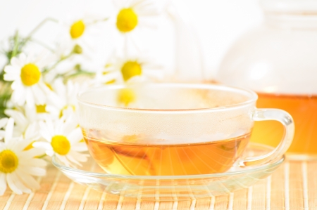 A teacup and a teapot with herbal chamomile teaの写真素材