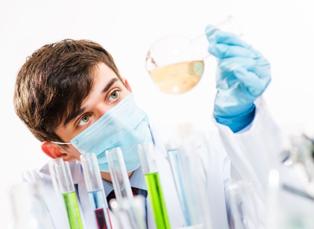 Portrait of a scientist working in the lab examines a test tube with liquidの写真素材