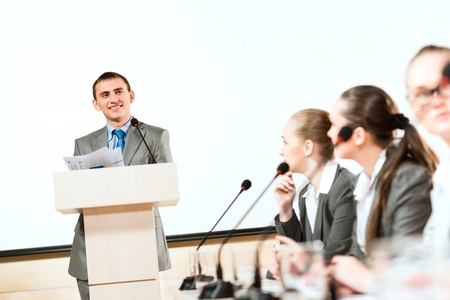 businessmen communicate at the conference, sitting at the table, on the table microphones and documentsの写真素材
