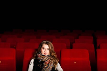 young attractive woman sitting in a cinema, enjoying a movieの写真素材