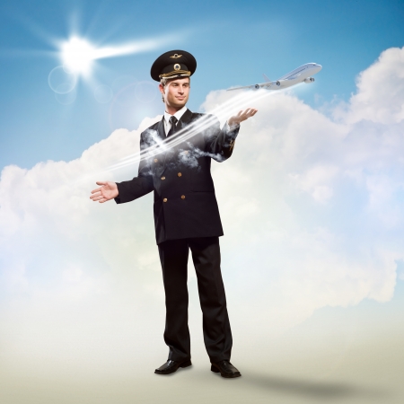 pilot in the form of extending a hand to a flying airplane with sky, clouds and sunの写真素材