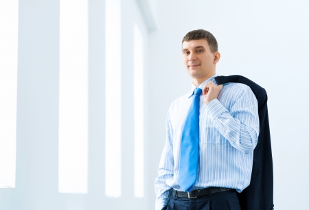 Portrait of a successful businessman, took off his jacket and hung it on his shoulderの写真素材