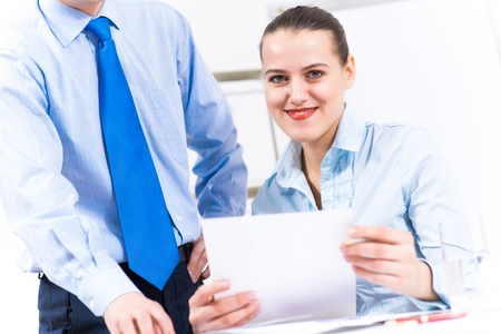 colleagues discuss the reports at a desk in the office, working together in businessの写真素材