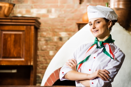 portrait of a cook, is on the traditional kitchen, crossed her armsの写真素材