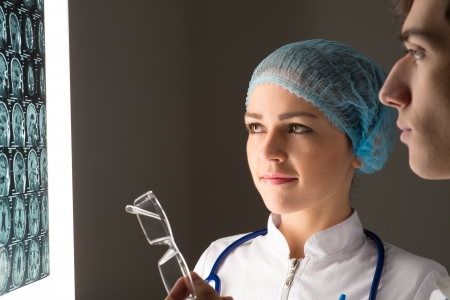 medical colleagues confer near the x-ray image fixed on the glowing screenの写真素材