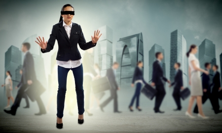 young blindfolded woman  seeking a way out in a crowdの写真素材