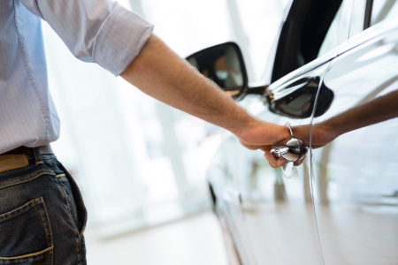 man opens the door to a new car, car inspection in the showroomの写真素材