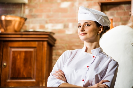 portrait of a cook, is on the traditional kitchen, crossed her armsの写真素材